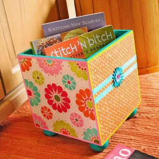 Storage doesn't have to be boring! I used bright paints, paper and decoupage on this wood storage bin - and now I'm storing my books in style.