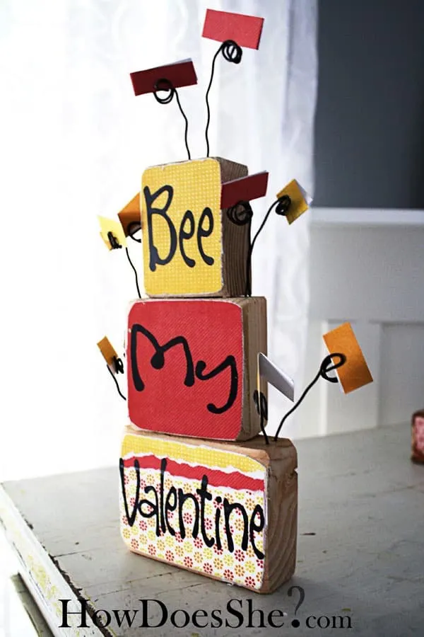 Leave sweet messages for your family with this love note Valentine's Day decor, built with scrap wood and decorated with pretty papers and Mod Podge.