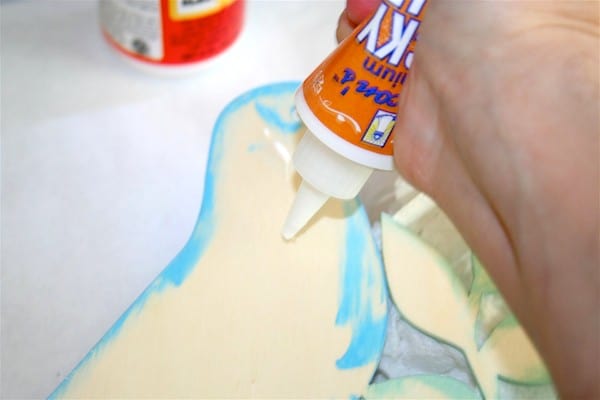 Adding craft glue to the back of a wood shape
