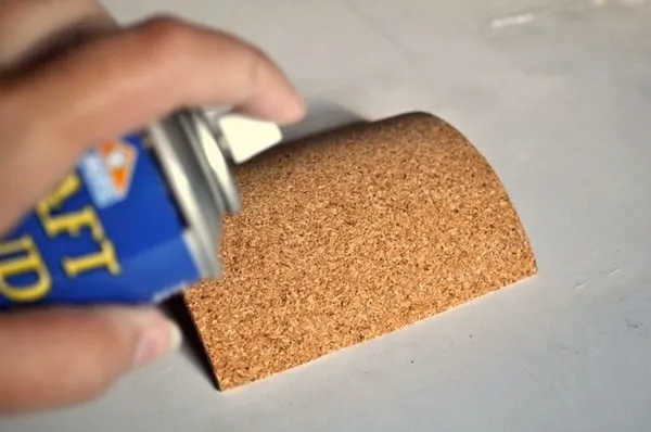 Spraying adhesive on a cork square