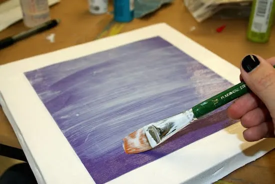 Applying Mod Podge over the top of the purple paper