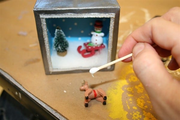 Gluing in a small reindeer ornament with a q tip
