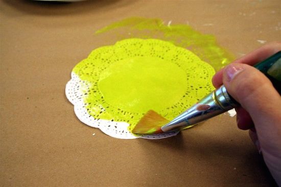 Painting a paper doily with bright light  green