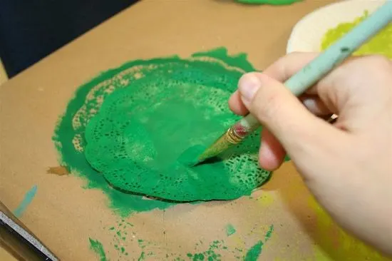 Painting a paper doily with bright green