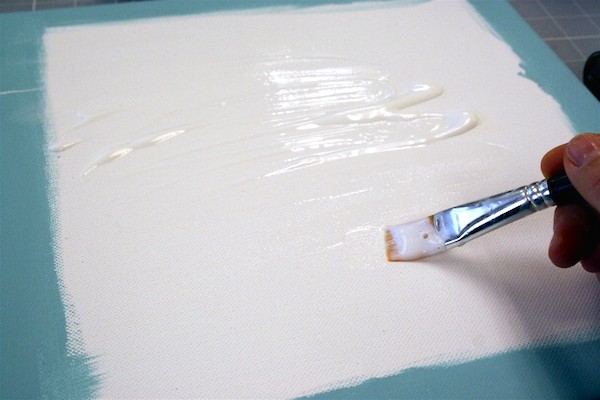 Spread the Mod Podge across a canvas with a paintbrush