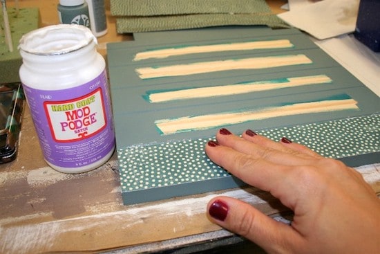 Smoothing paper down on the Mod Podge on the chair seat