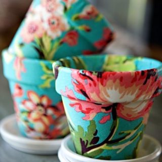Decoupage fabric on terra cotta in this fun DIY flower pot project. You'll love the transformation from boring to fun and pretty!
