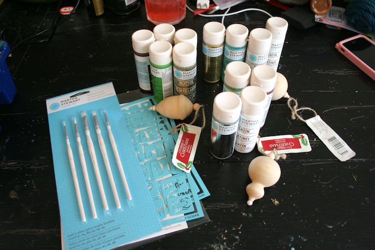 Craft paint, brushes, wood ornaments, and adhesive stencils