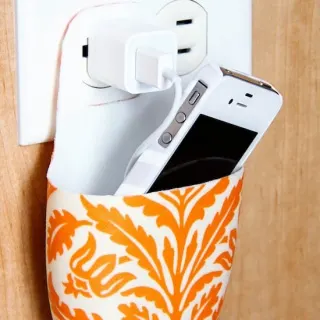 Not sure where to put your phone while it's charging? Make a cell phone holder from a lotion bottle using Mod Podge, and keep it near the plug.