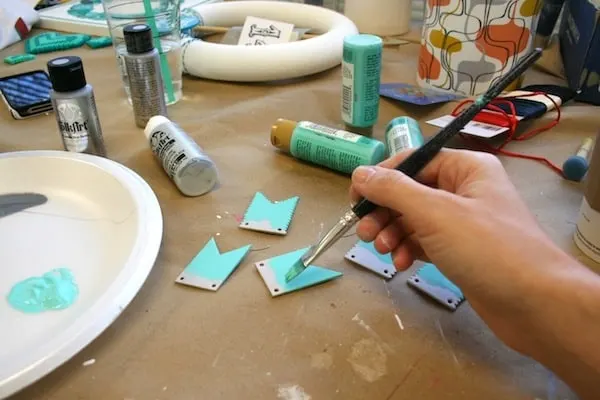Painting chipboard bunting pieces with aqua paint