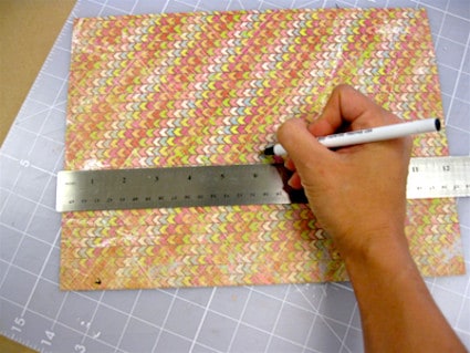 Measuring the scrapbook paper using a pen and a ruler