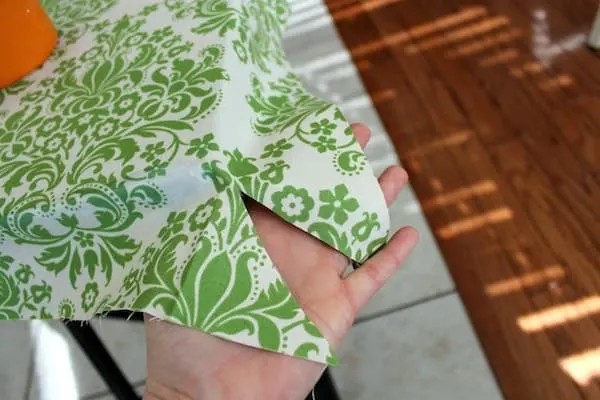 Hand showing the cut edge of the fabric to fold under