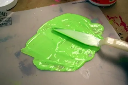 Spreading green Mod Podge out onto a non-stick surface