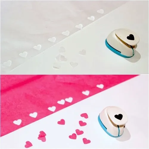 Cutting pink and white hearts out of tissue paper with a heart punch