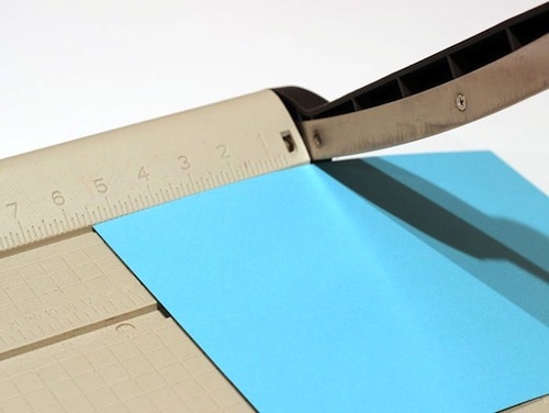 Cutting blue cardstock with a paper cutter