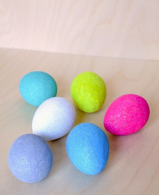 Glitter Easter eggs laying on a wood surface