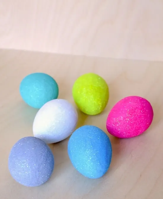 Glitter Easter eggs laying on a wood surface