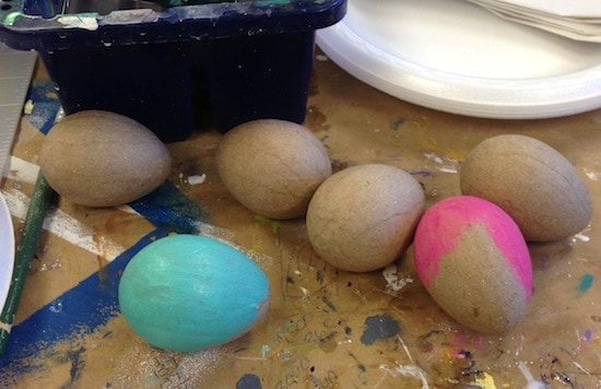 Paper mache Easter eggs being painted with acrylic paint