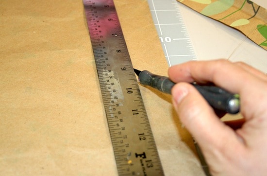 Trimming wrapping paper with a ruler and a craft knife