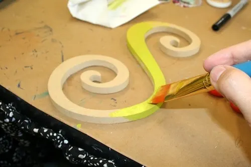 Painting the wood letter S with yellow citron paint