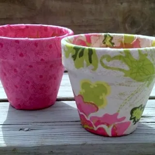 Use pretty fabric on these Mod Podge terra cotta pots for the perfect spring craft project! Makes a great container garden - or gift idea.