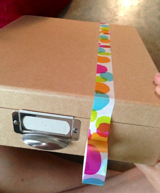Applying washi tape to the top of a paper mache office box