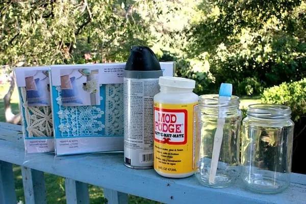 Lace, black spray paint, Mod Podge, glass jars, and a paintbrush