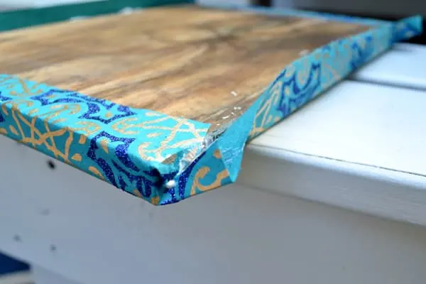 Folded wrapping paper corners on the edge of a wooden tabletop