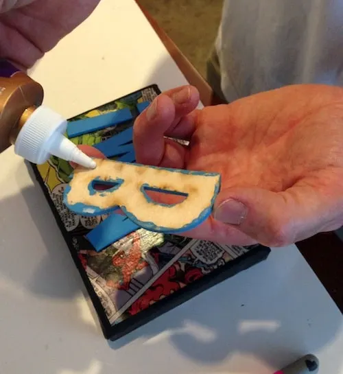 Adding glue to the back of a painted wood letter "B"