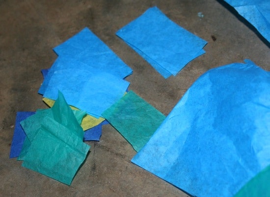 Various colors of tissue paper cut into squares