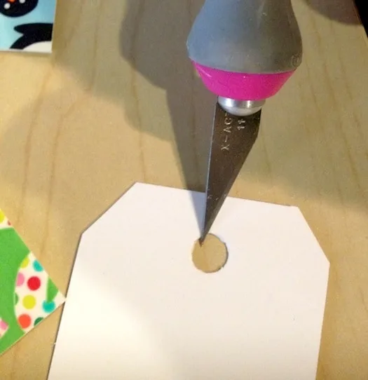 Cutting out the circle on the gift tag with a craft knife