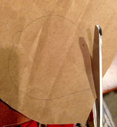 Cutting out an ornament shape from kraft paper using scissors