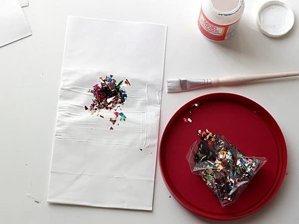 Mod Podge spread onto a white bag and a little bit of metallic confetti on top
