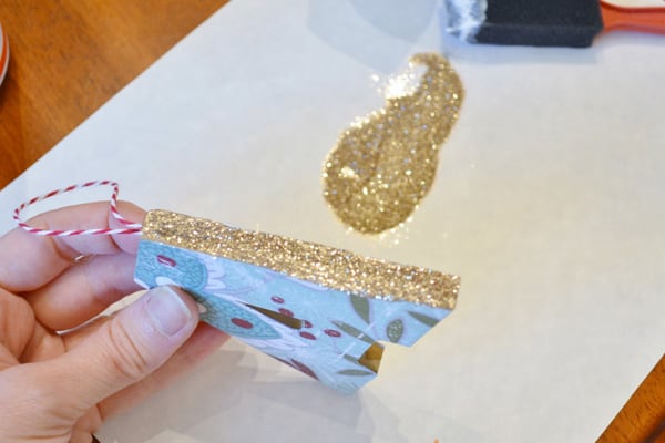 adding gold glitter to initial christmas ornaments