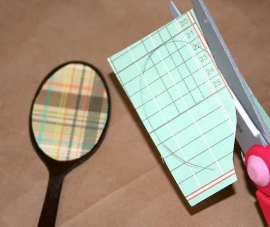 Cutting a shape out of scrapbook paper with scissors
