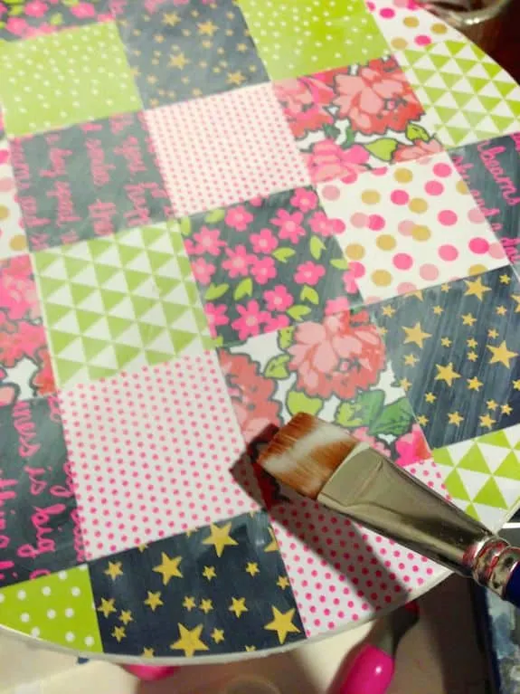 Applying Mod Podge to the top of the scrapbook paper
