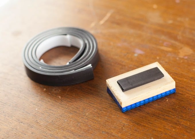 Roll of adhesive magnet laying next to a letter magnet
