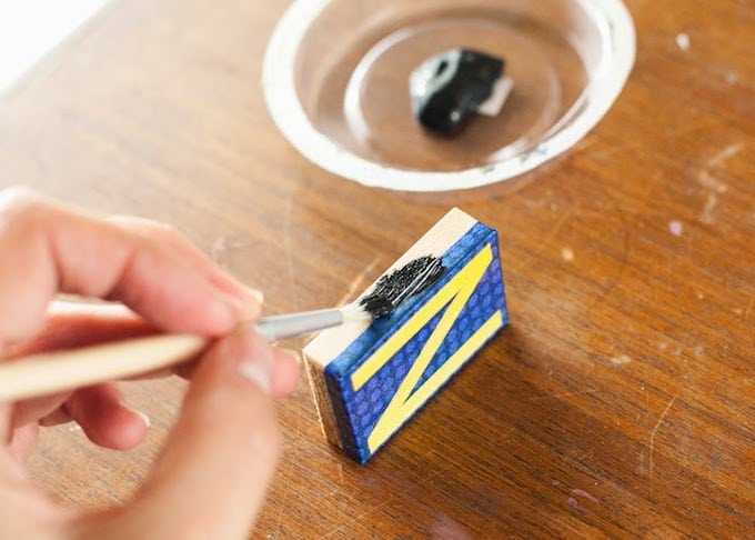Painting the sides of the letter magnets with black paint