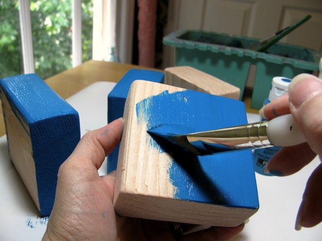 Painting the blocks with a coat of blue paint