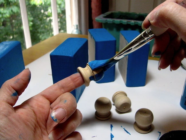 Painting the finial dowels with blue paint