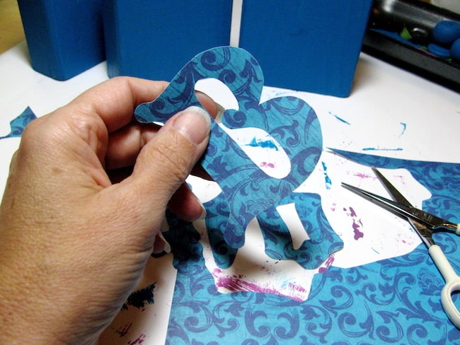 Cutting letters out of scrapbook paper with scissors