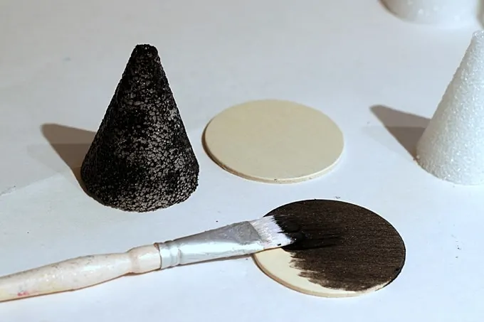 Painting the cones and wood circles with black paint