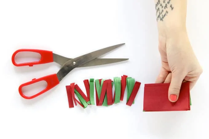 Scissors and tissue paper cut into long rectangular strips