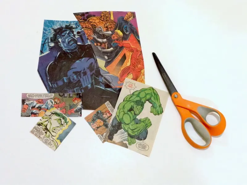 Comic book pages cut into smaller pieces and a pair of orange handled scissors