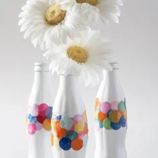 Recycle old Coke bottles into DIY confetti vases - all you need is a little bit of spray paint and Mod Podge. This craft is so easy!