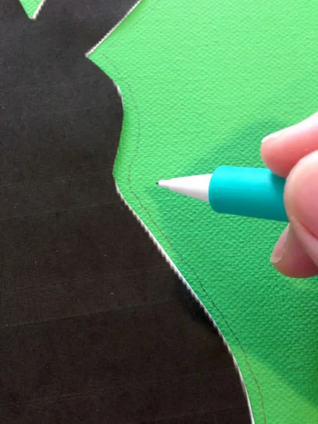 Tracing the bunny silhouette onto the green canvas