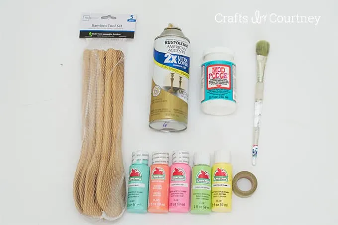 Bag of wooden spoons, gold spray paint, acrylic paint, tape, Dishwasher Safe Mod Podge, paintbrush