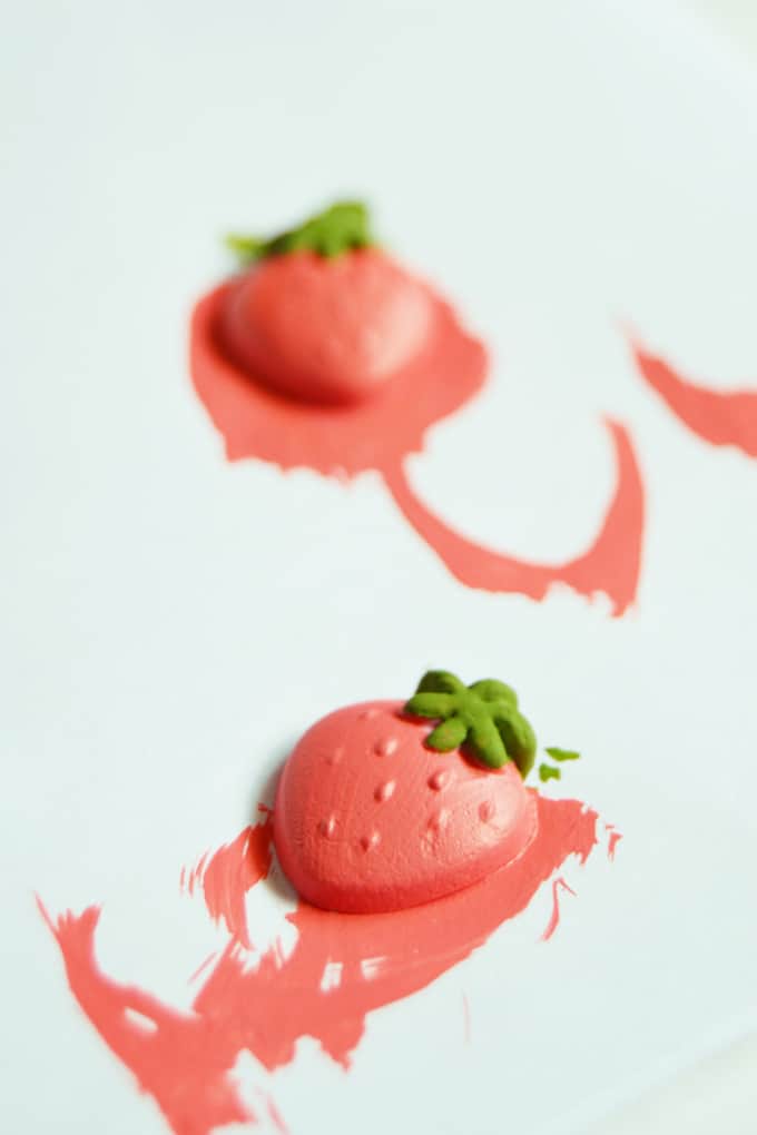 Painting the clay strawberries with coral pink and leaf green