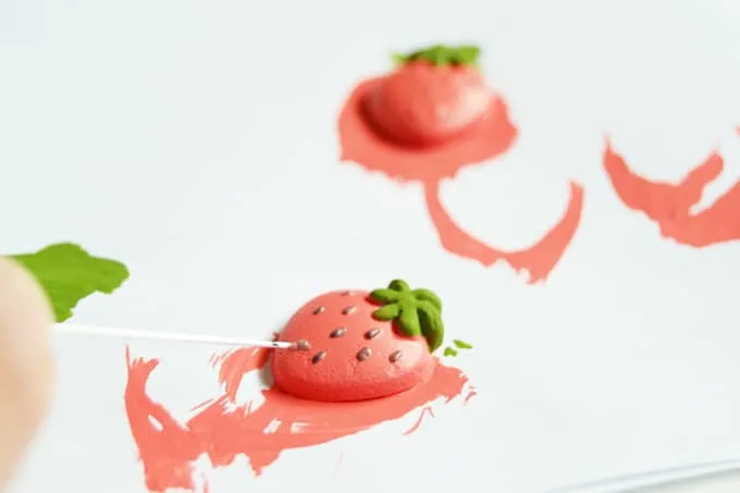 Painting strawberry seeds with a pin