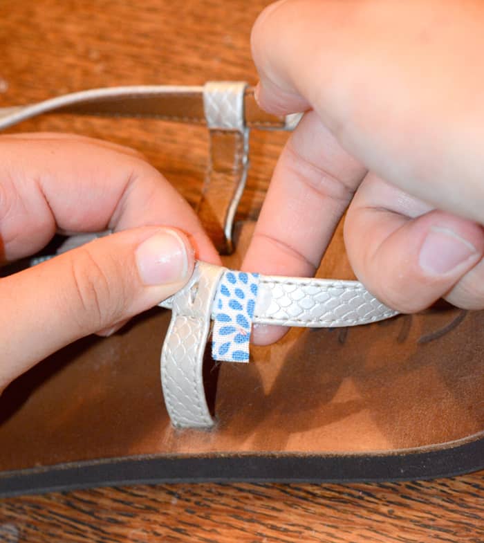Smoothing fabric around the back of the sandal strap with a finger